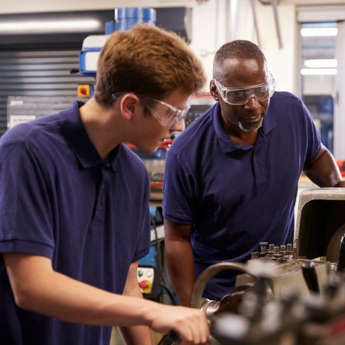 Engineer Showing Apprentice How To Use Lathe
